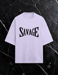 WYND oversized light purple tee with black arched SAVAGE typography on the chest. 260 GSM terry-knit cotton-polyester blend.